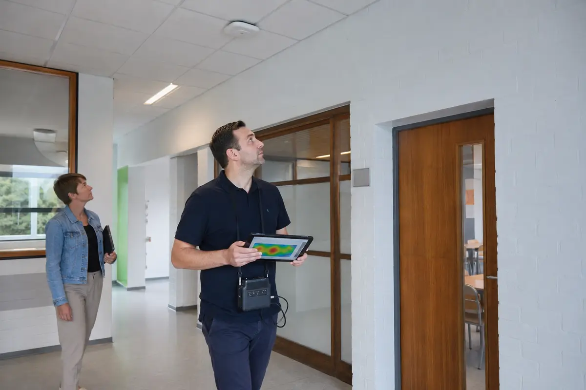 Ingénieur réseau réalisant une étude de couverture Wi-Fi dans un bâtiment belge